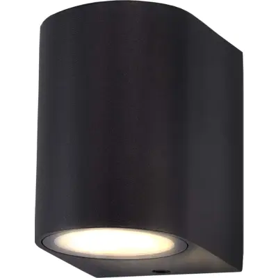 Black cylindrical wall sconce with a downlight, mounted on a white background, emitting a soft white glow.